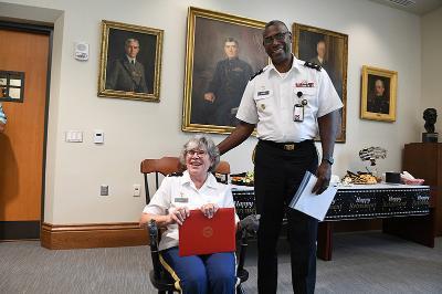 Maj. Gen. Cedric T. Wins ’85, superintendent, presents Col. Janet Holly a chair in recognition of her 37 years of service. She will retire from VMI on Sept. 1. –VMI Photo by Kelly Nye.